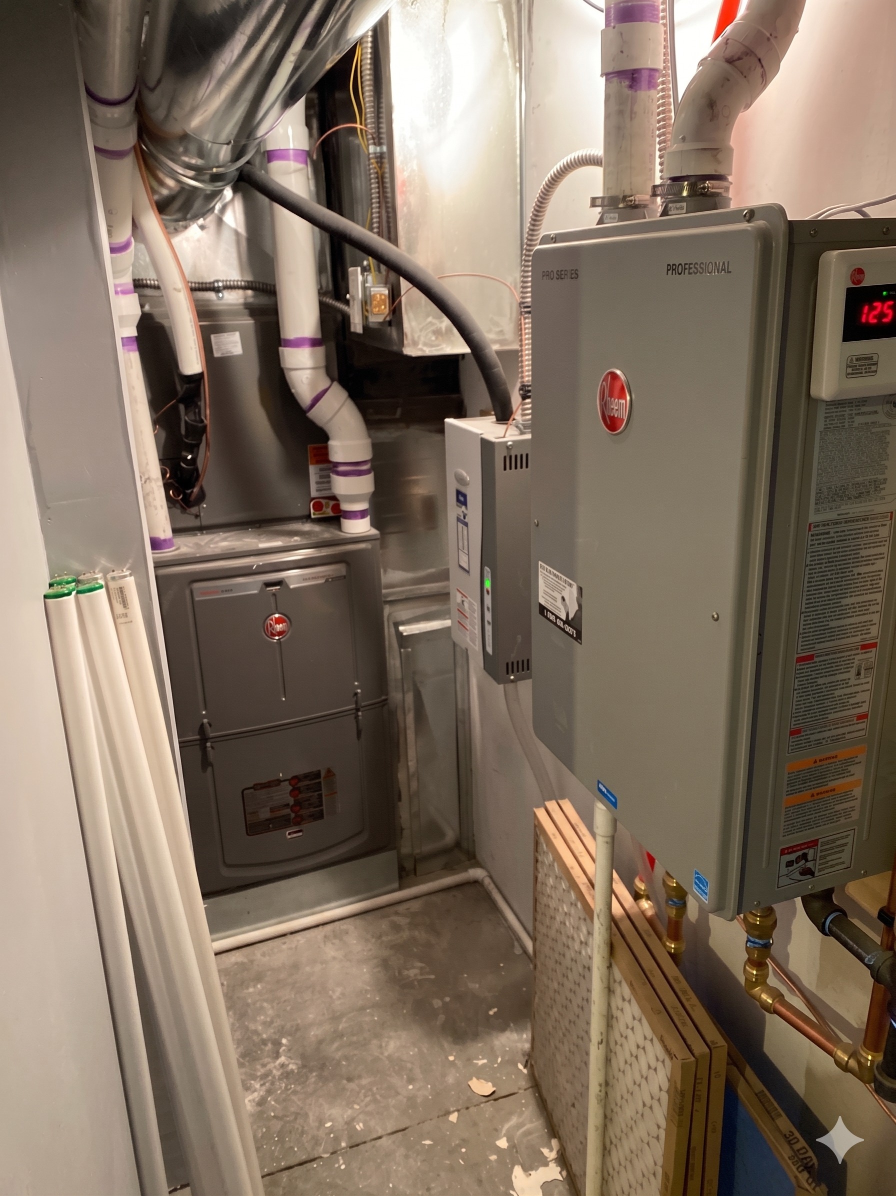 A clean Rheem furnace and Rheem tankless water heater install in a residential mechanical room.
